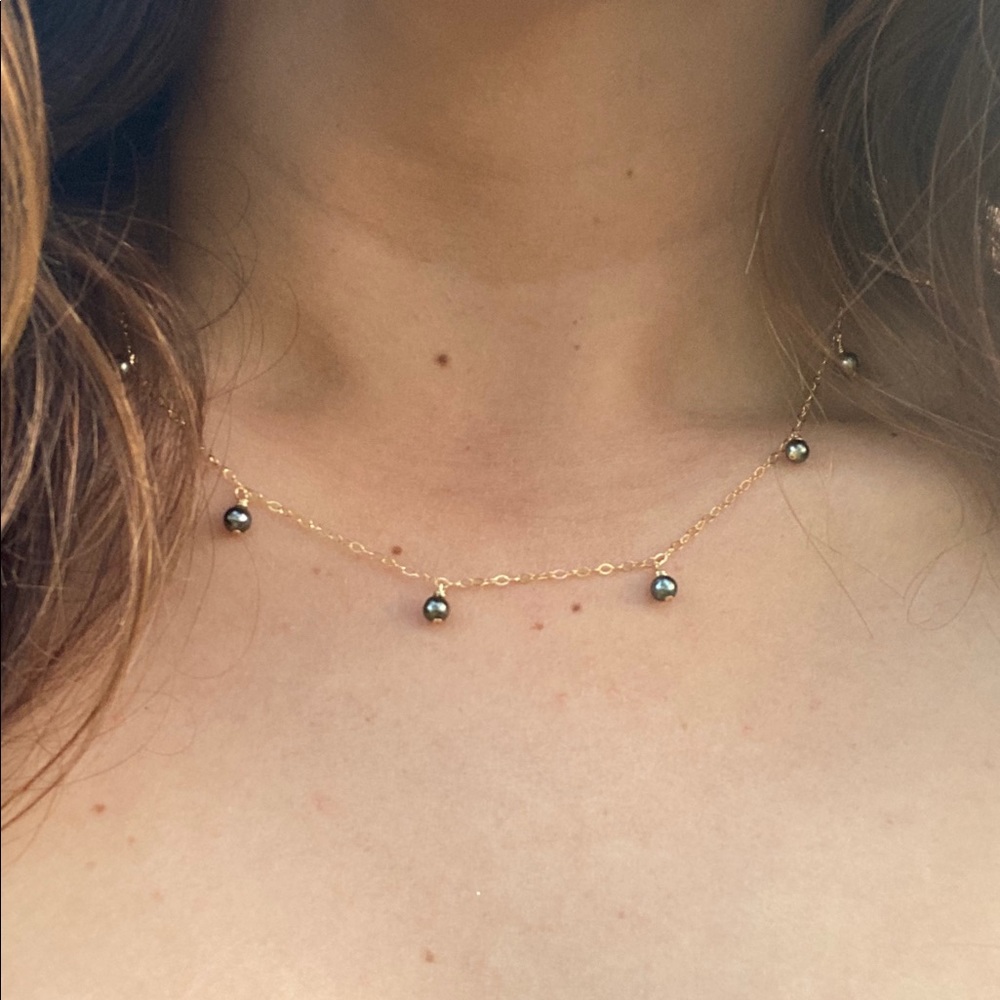 Small Tahitian pearls dangling on a necklace